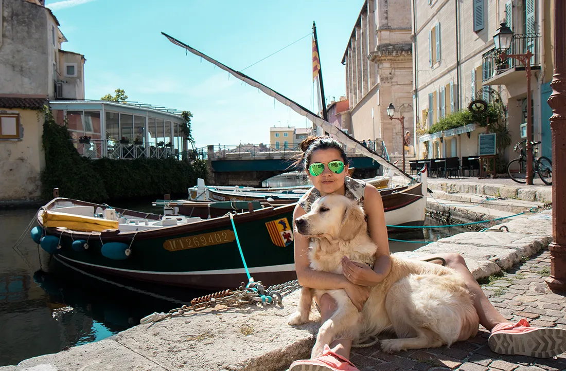 "Chien se promenant dans un village pittoresque du Sud de la France par une journée ensoleillée